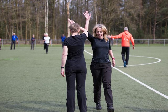 Wandeltrainersdag twee dames geven elkaar high five
